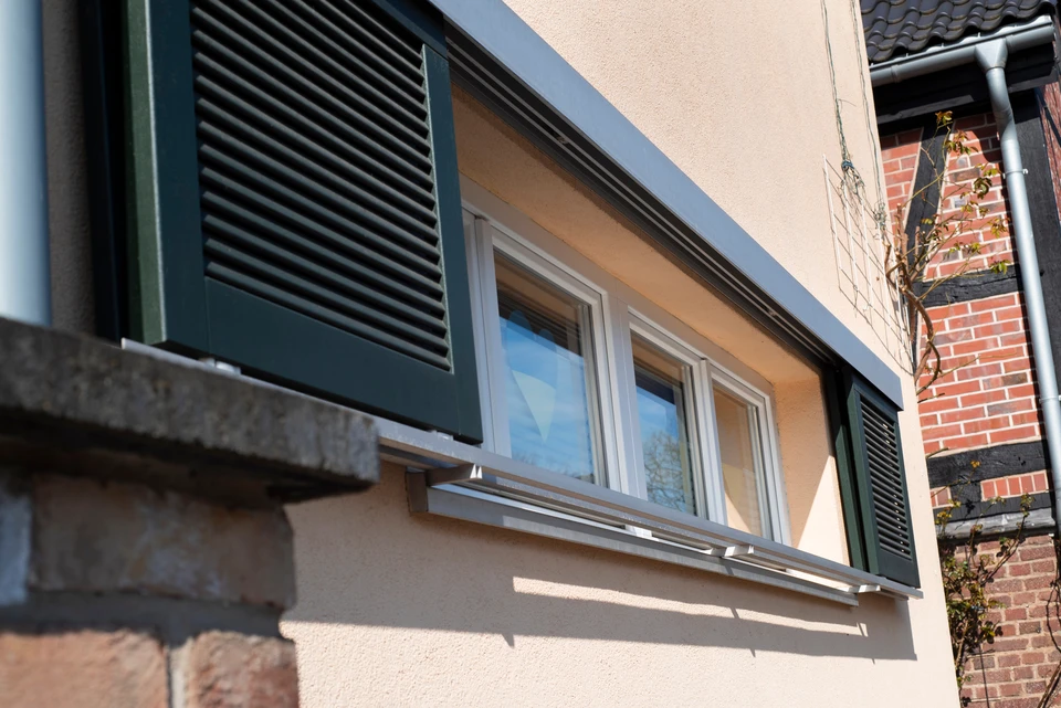 Façade extérieure d'habitation avec volet roulant moderne partiellement ouvert