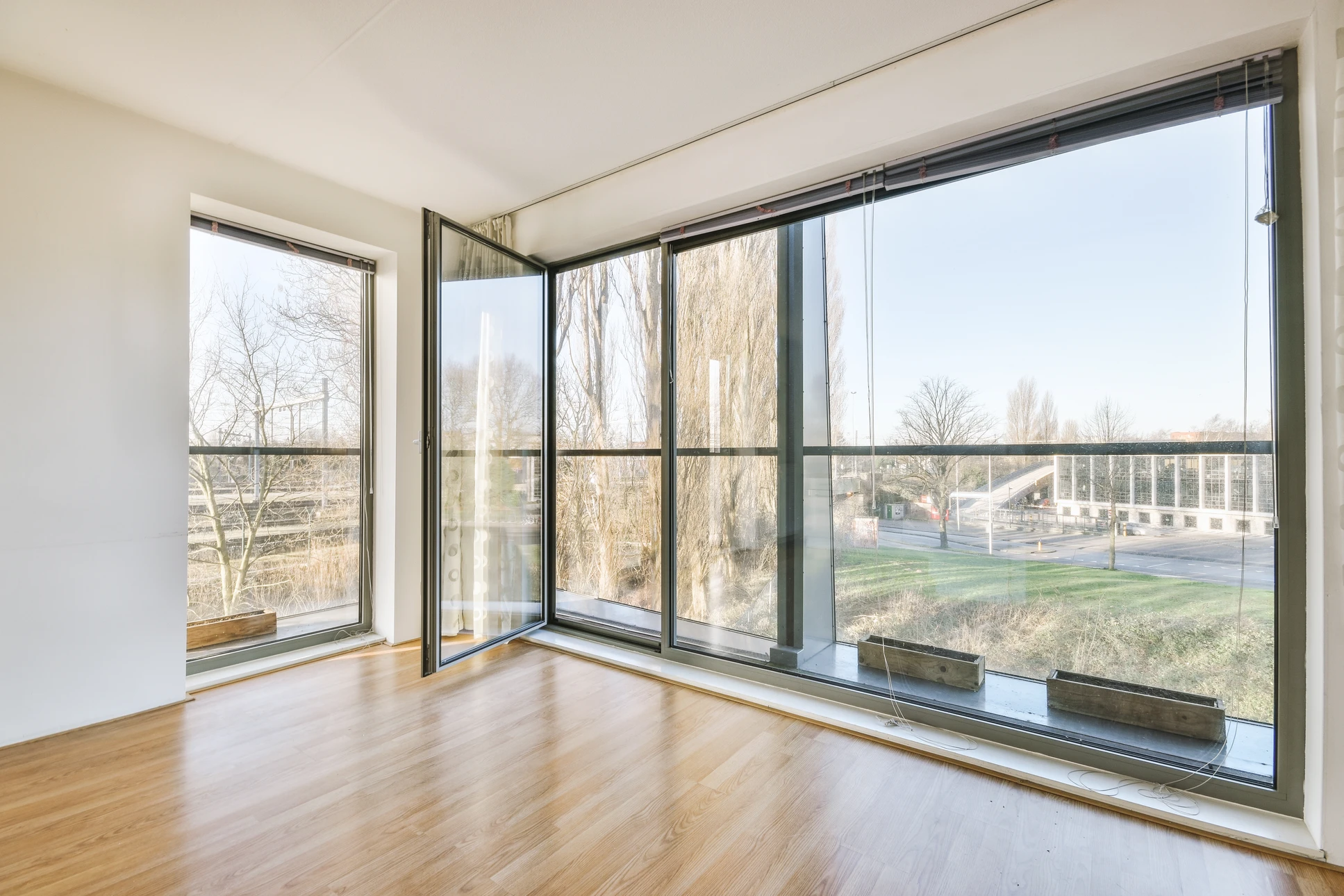 Terrasse moderne d'une maison contemporaine avec deux grandes baies vitr&eacute;es &eacute;quip&eacute;es de volets roulants &eacute;lectriques gris anthracite partiellement abaiss&eacute;s