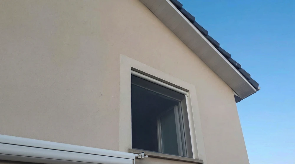 Extension contemporaine illuminée au crépuscule, véranda vitrée avec menuiseries aluminium anthracite, vitrage fixe et coulissant sans cadre apparent