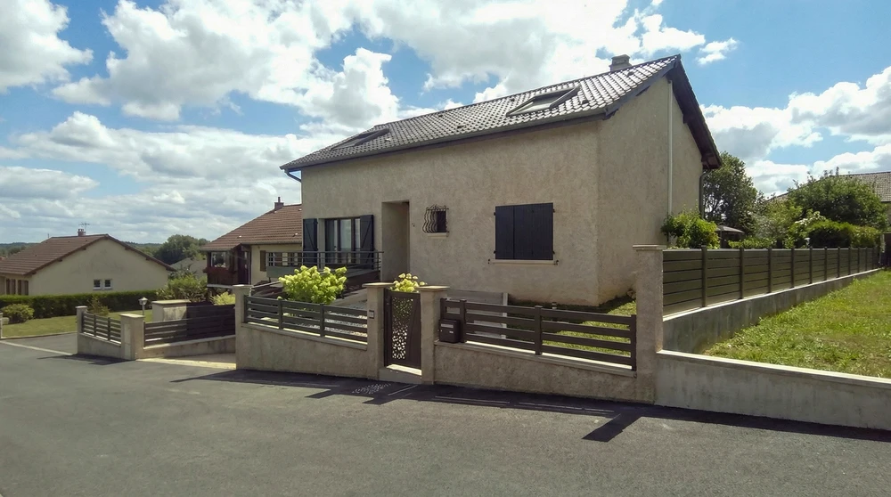 Véranda aluminium anthracite adossée à une maison individuelle, parois entièrement vitrées coulissantes sans cadre (vitrage feuilleté transparent), toiture en verre